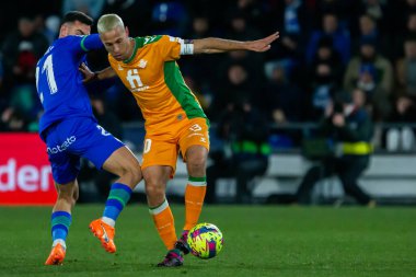 Madrid, Spain- January 28, 2023: Soccer match between Real Betis balonpie and Getafe F.C in Madrid. The Betis player Sergio Canales fights with an opponent for the ball.