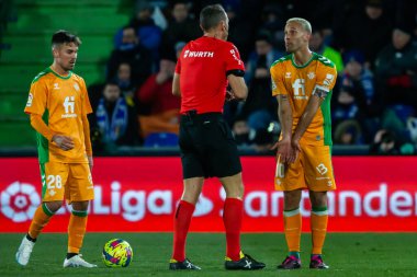 Madrid, Spain- January 28, 2023: Soccer match between Real Betis balonpie and Getafe F.C in Madrid. The players complain to the referee for a foul during the match.
