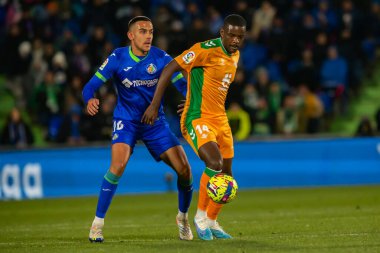 Madrid, Spain- January 28, 2023: Soccer match between Real Betis balonpie and Getafe F.C in Madrid. The Betis player Sergio Canales fights with an opponent for the ball.
