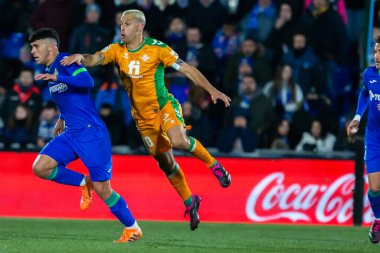 Madrid, Spain- January 28, 2023: Soccer match between Real Betis balonpie and Getafe F.C in Madrid. The Betis player Sergio Canales fights with an opponent for the ball.
