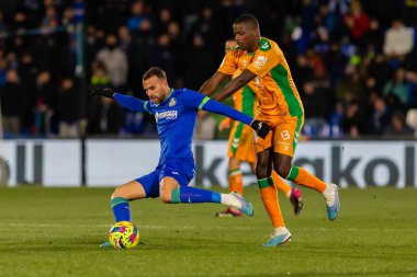 Madrid, Spain- January 28, 2023: Soccer match between Real Betis balonpie and Getafe F.C in Madrid. The Betis player Sergio Canales fights with an opponent for the ball.