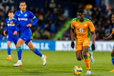 Madrid, Spain- January 28, 2023: Soccer match between Real Betis balonpie and Getafe F.C in Madrid. The Betis player Luiz Enrique fights with an opponent for the ball.