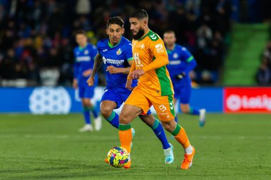 Madrid, Spain- January 28, 2023: Soccer match between Real Betis balonpie and Getafe F.C in Madrid. The Betis player Nabil Fekir fights with an opponent for the ball.