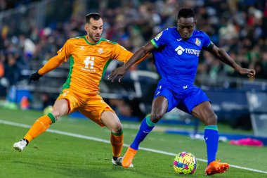 Madrid, Spain- January 28, 2023: Soccer match between Real Betis balonpie and Getafe F.C in Madrid. The Getafe player Djen Dakoman fights with an opponent for the ball.