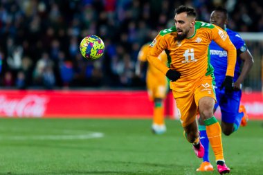 Madrid, Spain- January 28, 2023: Soccer match between Real Betis balonpie and Getafe F.C in Madrid. The Betis player Borja Iglesias running with the ball.