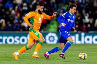 Madrid, Spain- January 28, 2023: Soccer match between Real Betis balonpie and Getafe F.C in Madrid. The Betis player Nabil Fekir fights with an opponent for the ball.