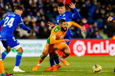 Madrid, Spain- January 28, 2023: Soccer match between Real Betis balonpie and Getafe F.C in Madrid. The Betis player Nabil Fekir fights with an opponent for the ball.
