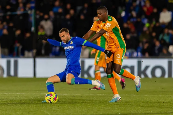 Madrid, Spain- January 28, 2023: Soccer match between Real Betis balonpie and Getafe F.C in Madrid. The Betis player Sergio Canales fights with an opponent for the ball.