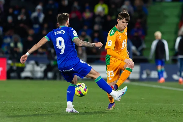 Madrid, Spain- January 28, 2023: Soccer match between Real Betis balonpie and Getafe F.C in Madrid. Juan Miranda fights for a ball on the field.