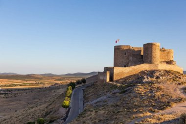Mills, Consuegra kasabasında. Tepedeki birkaç beyaz yel değirmeni ve kahverengi yel değirmeninin manzarası. Antik mimari. Çiftlik evleri.