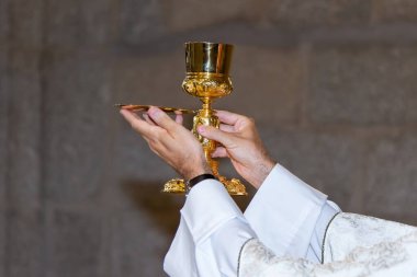 Ayin sırasında ayin. Katolik ritüeli. Beyaz cüppeli rahip ayini kutluyor..