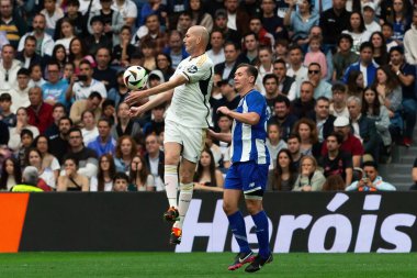 Madrid, Spain- March 23, 2024: Solidarity match between Real Madrid Leyendaa and Porto Vintage at the Santiago Bernabeu. Zidane returns to Real Madrid. Zidane dresses in white. Ziz with the ball clipart