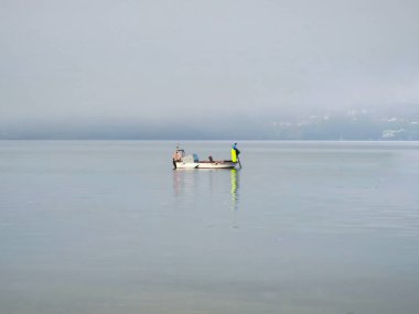 Ribadeo, İspanya - 13 Ağustos 2025: balıkçılık ekipmanları ve teçhizatı. Balık ağları ve toplar. Kabuklu deniz hayvanı kafesleri. Ribadeo limanına demir atmış bir balıkçı teknesi..
