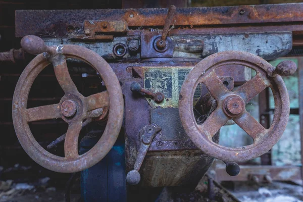 Terk edilmiş bir fabrikada eski paslı makineler..