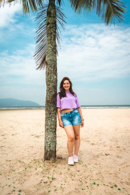 Brezilya 'nın Santos plajındaki palmiye ağacında poz veren Brezilyalı kadın.