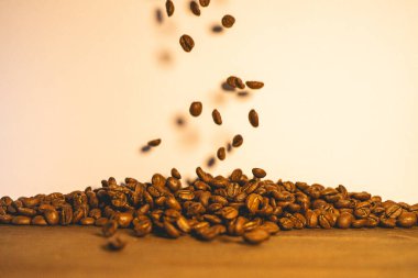 Fırında kahve çekirdekleri havada uçuşuyor. Kahve için arka plan.
