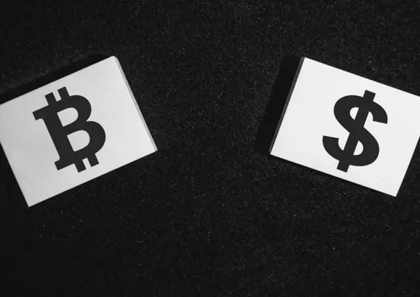 stock image Two sticky notes on a black background with a bitcoin and a dollar on it.