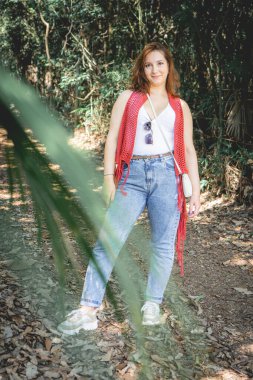 Brezilya 'da Jardim Botanik Bahçesi' nde yürürken kırmızı kazaklı Brezilyalı bir kadın poz veriyor..