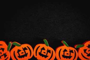 Siyah arka planda, kokteyl çubuklarından tahta balkabağı figürleri. Cadılar Bayramı.