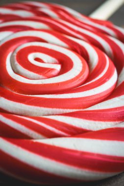 Tahta bir arka planda noel lolipopundan yaklaş. Kırmızı ve beyaz girdap. Noel için arkaplan.