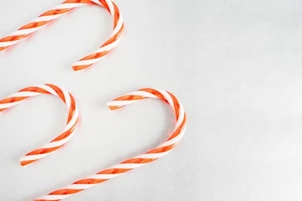 Gri arka planda duran Noel şekerleri. Noel Arkaplanı.