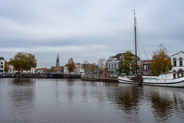 Delft, Hollanda 15 Ekim 2024. Delft Limanı, birkaç eski tekne ve şehrin silueti..