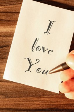 Ahşap bir arka planda not aldığın bir aşk.