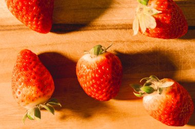 Tahta arka planda taze çilekler.