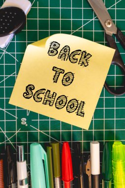 Yeşil arka planda okul malzemeleri. Okula Dönüş arkaplanı.