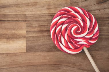 Ahşap arka planda kırmızı ve beyaz kıvrımlı Noel lolipopları. Noel arkaplanı.