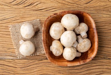 Paris mantarları ahşap masanın üzerinde bir kasede.