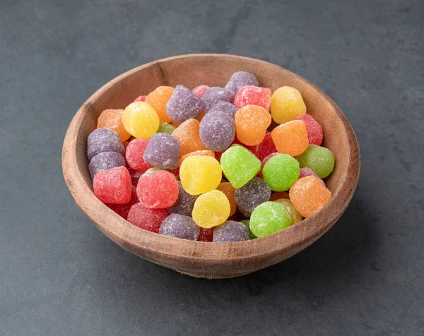 Colorful gum drop candies over stone background.