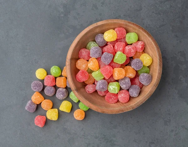 Colorful gum drop candies over stone background.
