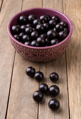 Jabuticabas ahşap masanın üzerinde bir kase üzerinde.