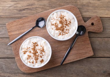 Canjica ya da munguza, tipik Brezilya beyaz mısır tatlı kreması ve ahşap masa üzerinde tarçın.