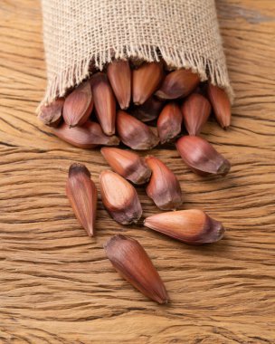 Ahşap bir masanın üzerinde çam ya da çam tohumları.