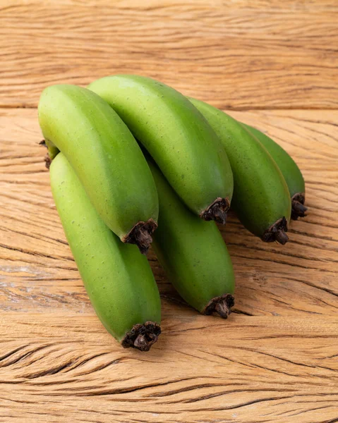 Banda Zielonych Bananów Nad Drewnianym Stołem — Zdjęcie stockowe
