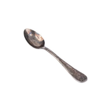 Old decorated metal tea spoon isolated over white background.