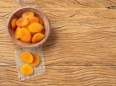 Tahta bir masanın üzerinde, fotokopi alanı olan kurumuş kayısılar..