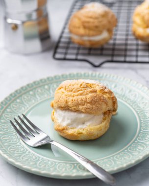 Choux kreması, yeşil tabakta vanilyalı kremalı pasta..