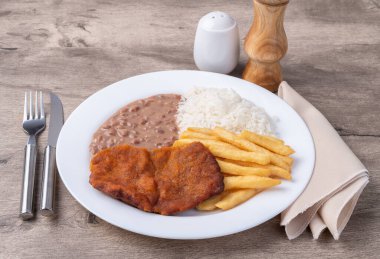 Milano bifteği, pirinç, fasulye ve patates kızartması. Tipik Brezilya idari yemeği..