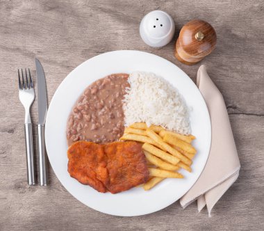 Milano bifteği, pirinç, fasulye ve patates kızartması. Tipik Brezilya idari yemeği..