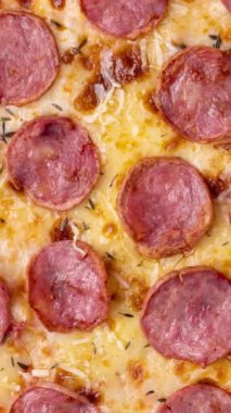 Dikey video. Calabrese sosis usulü pizzaya yakın çekim.