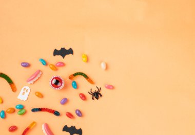 Fotokopi alanı olan turuncu arkaplan üzerindeki renkli şekerler.