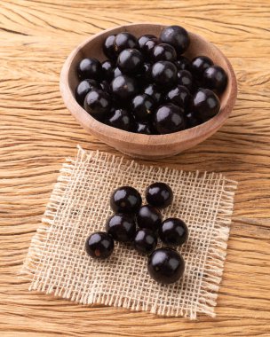 Jabuticabas ahşap masanın üzerinde bir kase üzerinde.