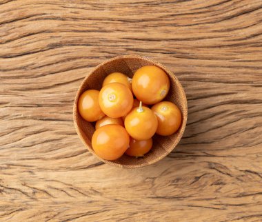 Tahta masanın üzerinde bir kâse üzerinde Physalis..