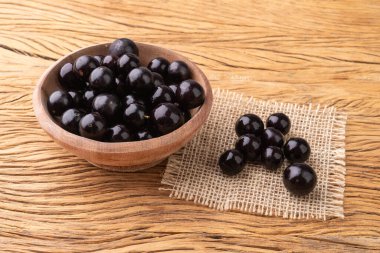 Jabuticabas ahşap masanın üzerinde bir kase üzerinde.