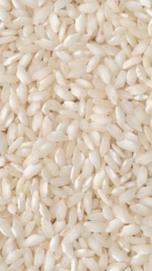 Dikey video. Yakın plan, çiğ carnaroli risotto pilavı. Yemek arkaplanı.