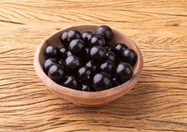 Jabuticabas ahşap masanın üzerinde bir kase üzerinde.