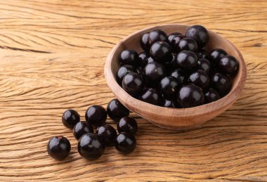 Jabuticabas ahşap masanın üzerinde bir kase üzerinde.